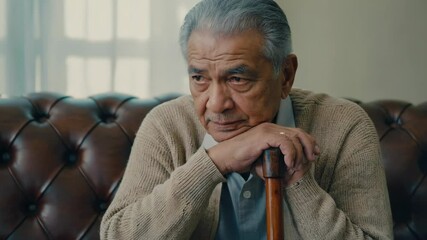 Aufkleber - A person sitting on a couch with a cane, possibly injured or in pain.