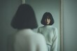 © whitestorm - A serene portrait of a young woman gazing intently at her reflection in the mirror, wearing a cozy white sweater with elegant bob haircut and bangs.