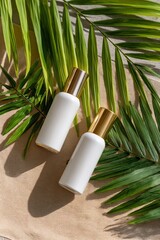 Poster - a cosmetic tonic and serum in blank packaging are showcased on a white wall with the shadows of palm