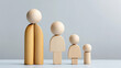 © Andres Mejia - Wooden family figures showing decreasing height representing family members on grey background