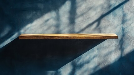 Poster - A wooden shelf mounted on a blue textured wall with shadows creating a minimalist aesthetic scene