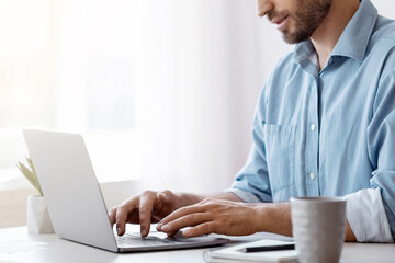 Poster - Handsome Male Freelancer Working On Laptop At Desk In Home Office, Answering Emails, Typing On Computer Keyboard, Communicating With Clients, Enjoying Remote Work, Side View With Copy Space