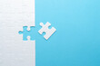 © AndS - Concept for problem-solving, teamwork, solutions, or missing connections. White jigsaw puzzle on a vibrant blue background with one missing piece. Minimalist composition with copy space.
