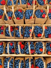 Poster - Bags filled with blueberries and strawberries displayed on a table.