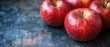 © AURA COLLECTIONS - Several vibrant red apples are arranged on an abstract painted background with cool and warm color variations