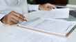 © Lek - asian businessman reviewing document at office. legal expert, professional lawyer working with laptop reading and checking financial documents and business contract before sign, close up shot