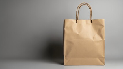 Poster - Empty brown paper shopping bag with rope handles on a light grey background, perfect for retail or environmental themes in marketing and design