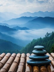 Poster - Balancing zen stones on a bamboo surface with a misty mountain range in the background for a peaceful atmosphere