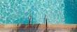 © Mirador - Top view of a swimming pool with clear blue water and metal ladder casting reflections in the sunlight. Perfect for summer themes, vacation concepts, or relaxation and wellness advertising.