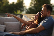 © Antonioguillem - Happy couple pointing sitting in a couch in a terrace