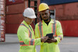 © Nassorn - Industrial engineer standing at shipping container yard inspecting cargo delivering loading as plan. Cargo manager and diverse ethnic worker checking import export container at logistic terminal dock.