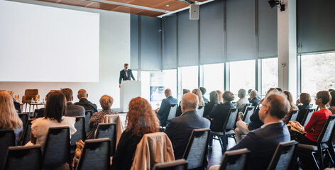Wall Mural - speaker giving a talk in conference hall at business event. rear view of unrecognizable people in au