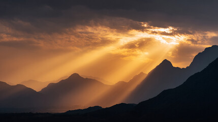 Poster - Golden sunrise rays pierce through dramatic clouds over silhouetted mountains