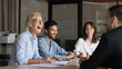 © fizkes - Happy lady leader laughing at diverse corporate board meeting. Business people communicate, executive older lady manager talking with colleagues, enjoy office life. International team having fun