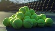 © Photo - Pile of bright green tennis balls resting on the court after a match detailed close-up view
