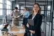 © standret - Female employee is posing. Business people are working in the office
