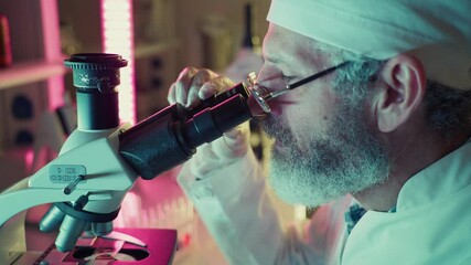 Wall Mural - medical researcher looking through microscope, performing scientific experiment in modern laboratory