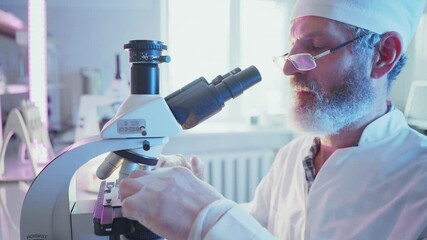 Wall Mural - focused scientific professional in white lab coat carefully adjusting high tech microscope while ana