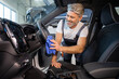 © zinkevych - Bearded man worker cleaning automobile salon with rag