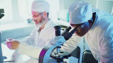 Wall Mural - medical research scientists working in modern laboratory, african american doctor using microscope, 