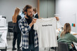 © standret - T-shirt with sample print text on it. People are working by the sewing machines indoors