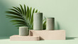 © PhotoArtHub - Three green cylindrical containers on beige podiums, beside a palm leaf against a pale green background, showcasing a minimalist product display