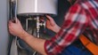 © keshia - Plumber installing new water heater in basement. Featuring expertise and skill