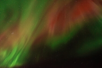 amazing aurora borealis in the starry sky. green and red northern lights in iceland