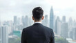 © Suryanto - Businessman in Black Suit Stands Facing a City Skyline from Inside a Modern High Rise Office