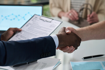 Poster - Close-up of manager shaking hands with customer to conclude a deal at meeting