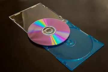 Aufkleber - A computer compact disc in an open case with rainbow reflections on it, on a dark background, close-up shot, the end of old technology from the 20th century, and forgotten technologies.