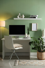 Aufkleber - Home office. Comfortable workplace with desk, computer and lamp near light green wall in room