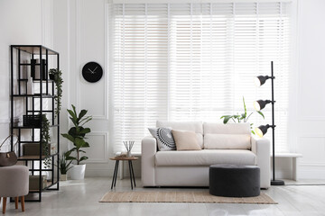Poster - Stylish shelving unit with decor and sofa in room