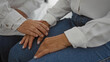 © Krakenimages.com - Hands of two women, doctor and patient, in a supportive gesture in a clinic setting; they are dressed casually, symbolizing a comforting and empathetic healthcare environment.