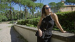 © Krakenimages.com - Woman enjoying sunny day in villa borghese gardens, rome, wearing sunglasses, black dress, smiling against natural backdrop, embodying youthful beauty and relaxation.