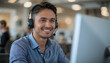 © Silver - A friendly customer service representative wearing a headset smiles while working at his computer, ready to assist customers with their inquiries.