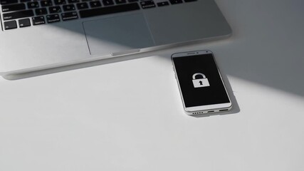 Aufkleber - Secure login concept features a smartphone displaying a lock screen icon near a laptop on a white table, suggesting data protection and digital security