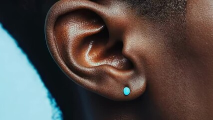 Poster - Turquoise gemstone adorning human ear, highlighting natural curves and adding sophisticated elegance with minimalist jewelry design against pristine background