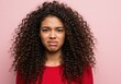© Selda - Portrait of a young black woman with long curly hair expressing strong disgust against pink.