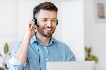 Poster - Hotline Operator. Handsome Young Man Customer Support Manager In Headset Working With Laptop Computer In Office, Consulting Clients Online, Managing Issues, Sitting At Desk, Free Space