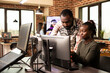 © DC Studio - Serious african american colleagues analyzing a startup project on a desktop monitor in a startup company. Determined black creative professionals working together at computer, refining designs.