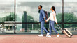 © Prostock-studio - Ready for travel. Happy black couple walking with suitcases near airport building, going to entrance, side view with copy space