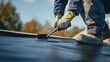 © Soulc - Roofer applying sealant to a roof at a construction site. Featuring focus and skill