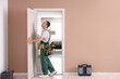 © Pixel-Shot - Male worker with tools examining door at home