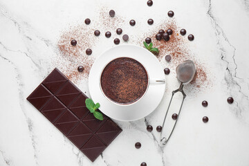 Wall Mural - cup of hot chocolate with cocoa powder, chips and strainer on marble background