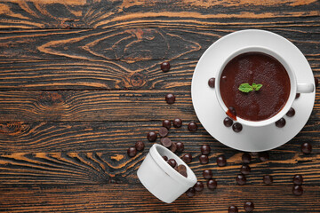 Wall Mural - cup of hot chocolate with chips and mint leaves on wooden background
