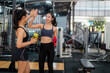 © PaeGAG - Two Young Women Giving High Five After Workout in Gym
