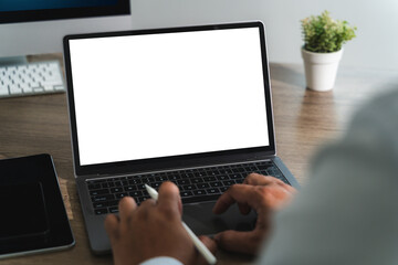 Poster -  A young businessman, sitting at a desk in a modern office, types on a laptop with a blank screen, communicating online in cyberspace.