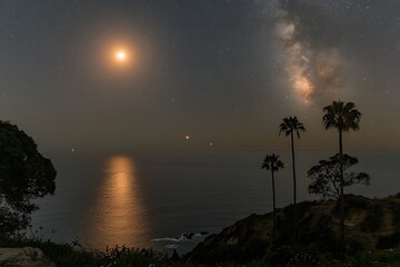 a beautiful ocean vista under a starry celestial sky at night