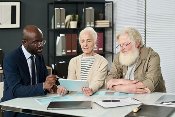 Poster - Senior couple learning to use application online on digital tablet during meeting with financial manager